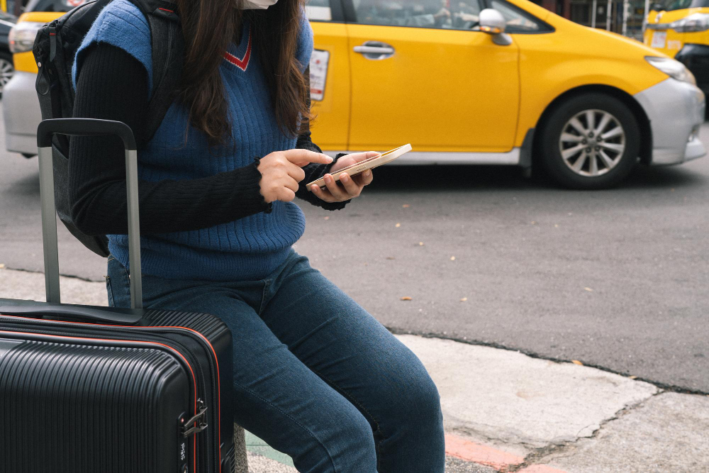 Persona con maleta solicitar un taxi en la calle.
