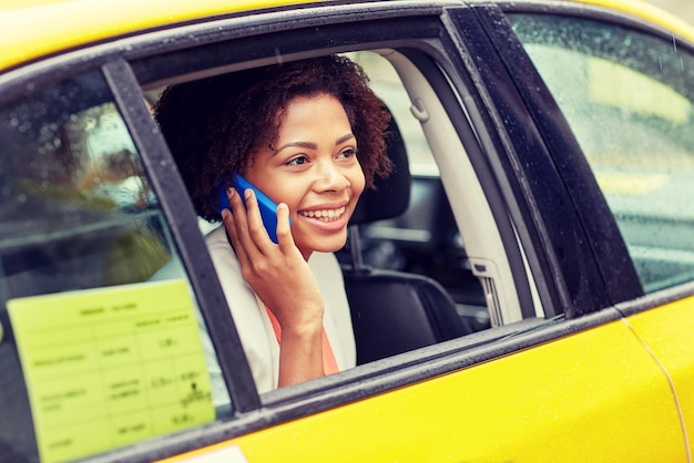 Mujer sonriente en un taxi amarillo.